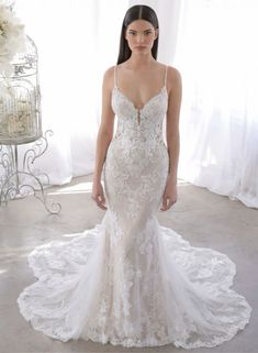 a woman in a white wedding dress standing next to a birdcage with flowers on it