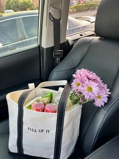 a bag with flowers in it sitting on the back seat of a car