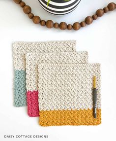 three crocheted placemats on top of a table next to a ball of yarn