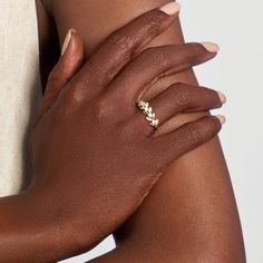 a woman's hand with a ring on her left wrist and the other arm behind her