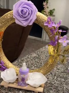 a close up of a mirror with flowers on it and a baby bottle in the middle