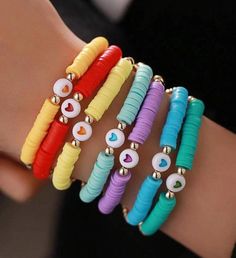 four different colored bracelets with hearts and eyes on each one hand, all in different colors