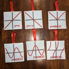 four coasters with red ribbon on them sitting on a table