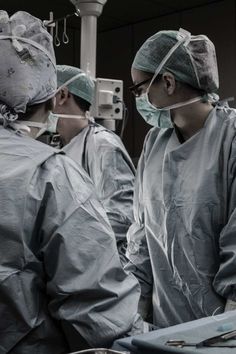 three surgeons are performing surgery in an operating room