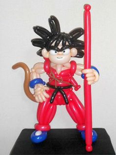 a figurine of a cartoon character holding a red pole and wearing black hair