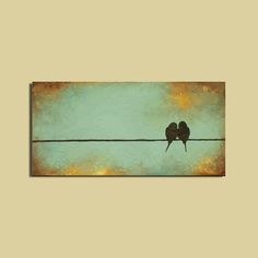 two birds sitting on top of a wire