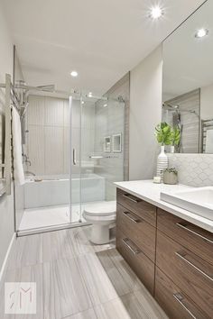 a bathroom with a sink, toilet and shower stall in the middle of the room