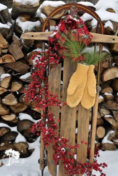 a wooden sled with red berries and yellow mitts hanging from it's side