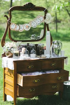 an old dresser with baby's first year decorations on it and flowers in front of the mirror