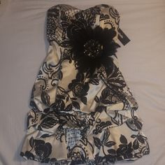 Size 1 Black And White Coctail Dress Can Be Worn With Or Without Feathered Pin Never Been Worn In Perfect Condition New With Tags Elegant Floral Print Mini Dress For Prom, Elegant Floral Print Prom Mini Dress, Elegant Strapless Mini Dress With Floral Print, Elegant Floral Print Strapless Dress For Formal Occasions, Elegant Strapless Floral Print Dress For Formal Occasions, Satin Floral Print Party Dress, Evening Floral Print Satin Mini Dress, Elegant Satin Mini Dress With Floral Print, Elegant Floral Print Strapless Dress For Night Out