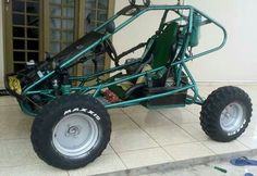 an off road buggy is parked in front of a building with tools on the ground