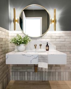 a bathroom sink with a mirror above it and a vase filled with flowers on the counter