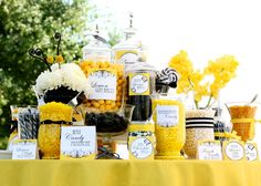 a table topped with lots of candy and candies next to a yellow table cloth