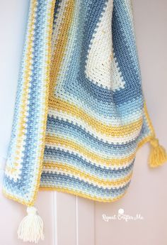 a crocheted blanket hanging on the wall