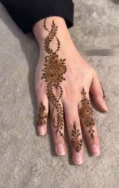 a woman's hand with henna tattoos on it