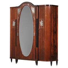 a wooden armoire with an oval mirror on the front and two legs inlaid to it