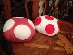 two red and white polka dot pillows sitting on top of a wooden table