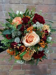 a bouquet of flowers sitting on top of a brick wall