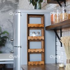 an old fashioned refrigerator with shelves and jars on the door, next to a vase filled with flowers