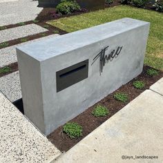 a concrete mailbox with the word thee written on it