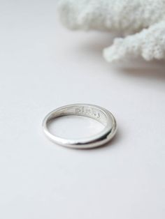 a silver ring sitting on top of a white surface