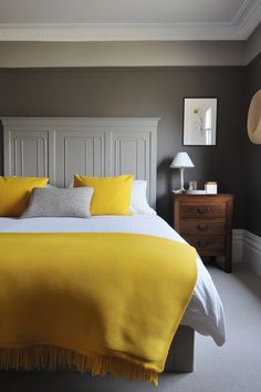 a bed with yellow blankets and pillows in a bedroom