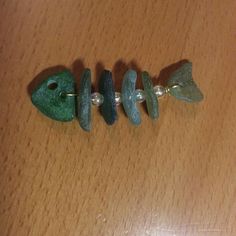 three pieces of jewelry sitting on top of a wooden table