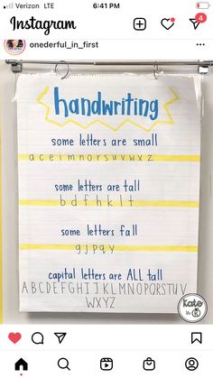 a handwritten poster hanging on the side of a wall next to a computer keyboard