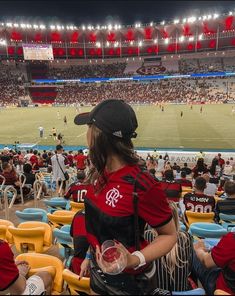 people sitting in the stands at a soccer game with their backs turned to the camera