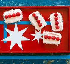 red tray with white frosting and raspberries arranged in the shape of stars