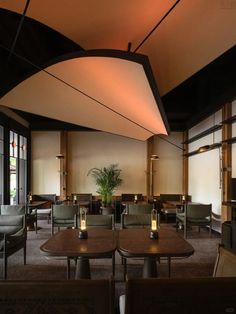 the interior of a restaurant with tables, chairs and couches in front of large windows