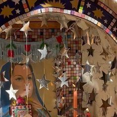 a mirror with stars hanging from it and a woman's face in the reflection