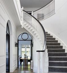 a staircase leading up to the second floor in a house with white walls and wood floors