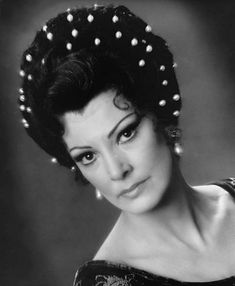 an old black and white photo of a woman with pearls in her hair, wearing a headdress