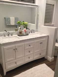 a bathroom vanity with two sinks and a large mirror