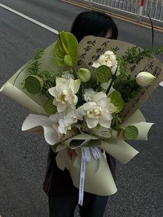 a woman holding a bouquet of flowers on the street