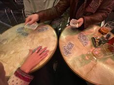 two people are playing cards at a table