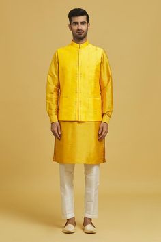 Mustard cotton silk bundi jacket with thread and sequin embroidery. Comes with a matching dupion silk based kurta and an off white dupion silk based Mexican pant.
Components: 3
Pattern: Embroidered
Type Of Work: Thread, Sequins
Neckline: Mandarin
Sleeve Type: Bundi: Sleeveless, Kurta Full
Fabric: Cotton Silk, Dupion Silk, Lining: Cotton
Color: Yellow
Other Details: 
Model is wearing size M/40
Occasion: Wedding - Aza Fashions Cotton Bollywood Nehru Jacket For Festive Occasions, Festive Cotton Silk Nehru Jacket With Dabka, Cotton Nehru Jacket For Puja And Eid, Festive Cotton Silk Nehru Jacket With Dabka Detailing, Cotton Nehru Jacket For Eid Puja, Festive Bollywood Cotton Silk Nehru Jacket, Festive Cotton Silk Nehru Jacket, Cotton Nehru Jacket For Festive Transitional Season, Festive Chanderi Nehru Jacket Straight Kurta