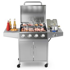 an outdoor grill with food cooking on the burner and bottles of beer next to it