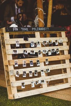 a wooden pallet with pictures pinned to it and the words pin your polaroids