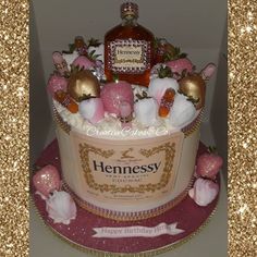 a birthday cake with a bottle of hennesy on top and flowers in the middle