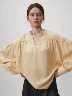 This product is a volume sleeve blouse that encapsulates modern elegance with its dramatic puff sleeves and airy silhouette. The design features a subtle V-neckline which adds a delicate touch, while the gathered details at the shoulders create an impactful volume, making it a statement piece for any wardrobe. - The blouse's voluminous sleeves are cinched at the wrists, balancing the proportions and adding sophistication to the overall design.- Made from a lightweight fabric, it provides a breezy feel and a comfortable fit for all-day wear.- The gathered shoulder detail and flowing silhouette offer a contemporary twist on the classic blouse.- Its relaxed and fluid design pairs effortlessly with both slim and wide-leg pants, making it a versatile choice for both casual and dressy occas Modern V-neck Blouse For Spring, Chic Puff Sleeve Bishop Top For Spring, Chic Puff Sleeve Top For Fall Daywear, Chic Blouse With Bishop Blouson Sleeves, Elegant Blouse With Voluminous Blouson Sleeves, Chic V-neck Blouse With Gathered Sleeves, Chic Puff Sleeve Top With Bishop Pleated Sleeves, Chic Billowy Padded Blouse, Chic Summer Puff Sleeve Top With Bishop Sleeves