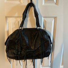 Stylish Boho Style Black Pebble Leather Bag. Soft Supple Leather Bag. Whipstitch Handles And Accents On Bag. Bag Has Tassels Front, Back And Sides. One Inside Back Wall Zip Pocket And 2 Open Pockets. Zipper Closure With A 8” Handle Drop. Excellent Used Condition. Approximately 15”L X 10”H X 3”W. Bohemian Black Bags With Leather Handles, Bohemian Black Shoulder Bag With Leather Handles, Bohemian Black Shoulder Bag For On-the-go, Black Hobo Bag With Leather Handles For On-the-go, On-the-go Textured Leather Black Hobo Bag, Black Pebbles, Lucky Brand, Pebbled Leather, Tassels