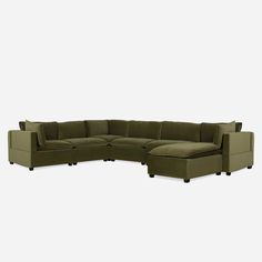 a green sectional couch with pillows on it