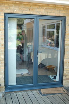 a woman is standing in front of a sliding glass door that leads to a patio