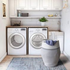 a washer and dryer in a laundry room with white cabinets, blue rug