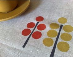 a table with a place mat and yellow plate next to an orange bowl on it