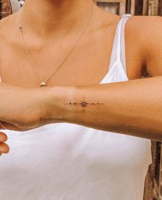 a woman with a cross tattoo on her arm