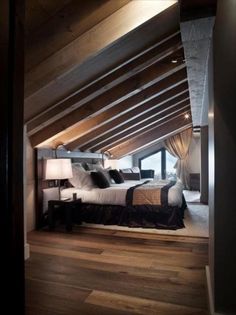 an attic bedroom with wood floors and white bedding