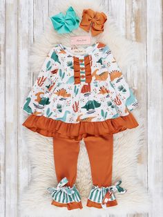 Get ready to roar with this dino-mite sister set! This playful girls outfit features a ruffle hem top adorned with a cute dinosaur print. The coordinating ruffle leggings complete the look so she's ready for her next adventure. Fits true to size. Body: 95% Polyester / 5% Spandex  Combo: 97% Cotton / 3% Spandex Accessor Woman Costumes, Ruffle Outfit, Ruffle Leggings, Childrens Clothing Boutique, Ruffle Romper, Children's Boutique, Cute Dinosaur, Hem Top, Dinosaur Print